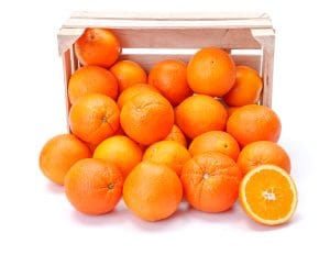 Ripe oranges spilling out of wooden crate. Citrus sinensis
